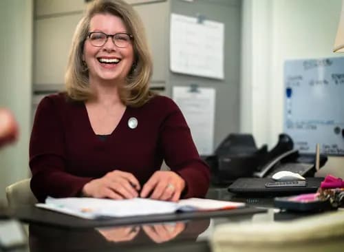 Professional photographed working at an office desk with workplace context