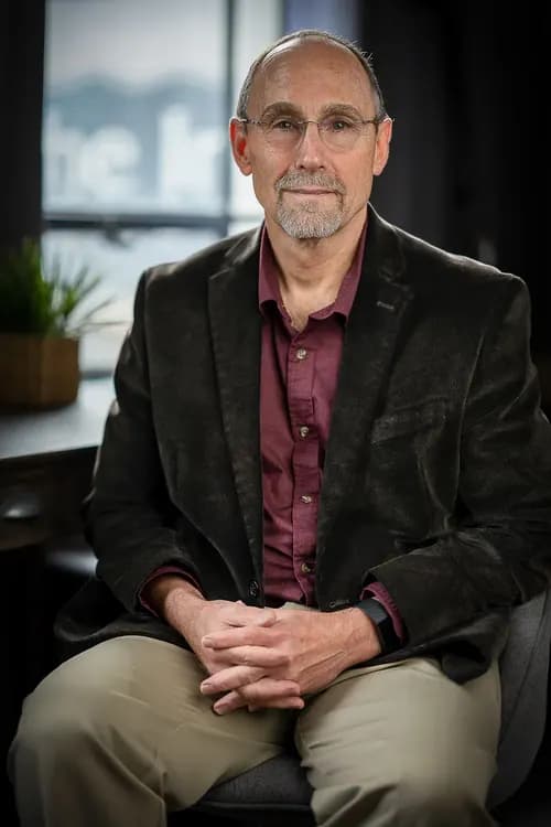 Seated professional portrait photographed in an office setting