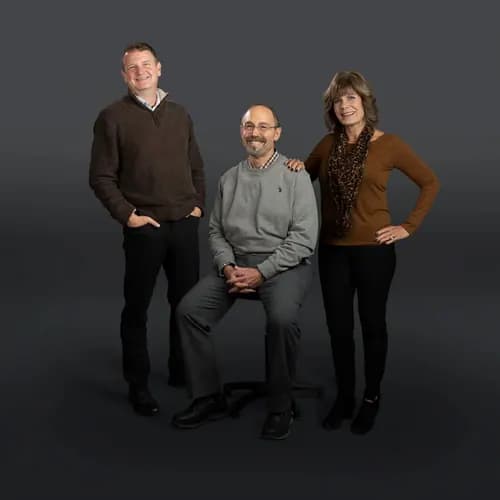 Three Conscious Profits colleagues photographed together in a professional studio group portrait