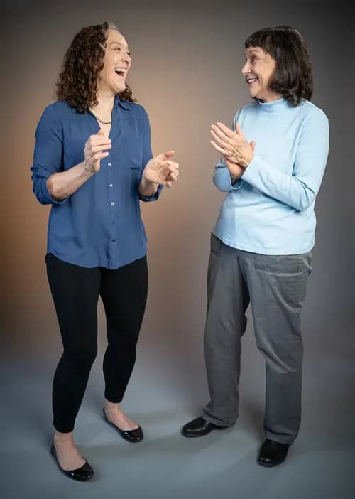 Two colleagues talking and laughing in a directed studio team portrait