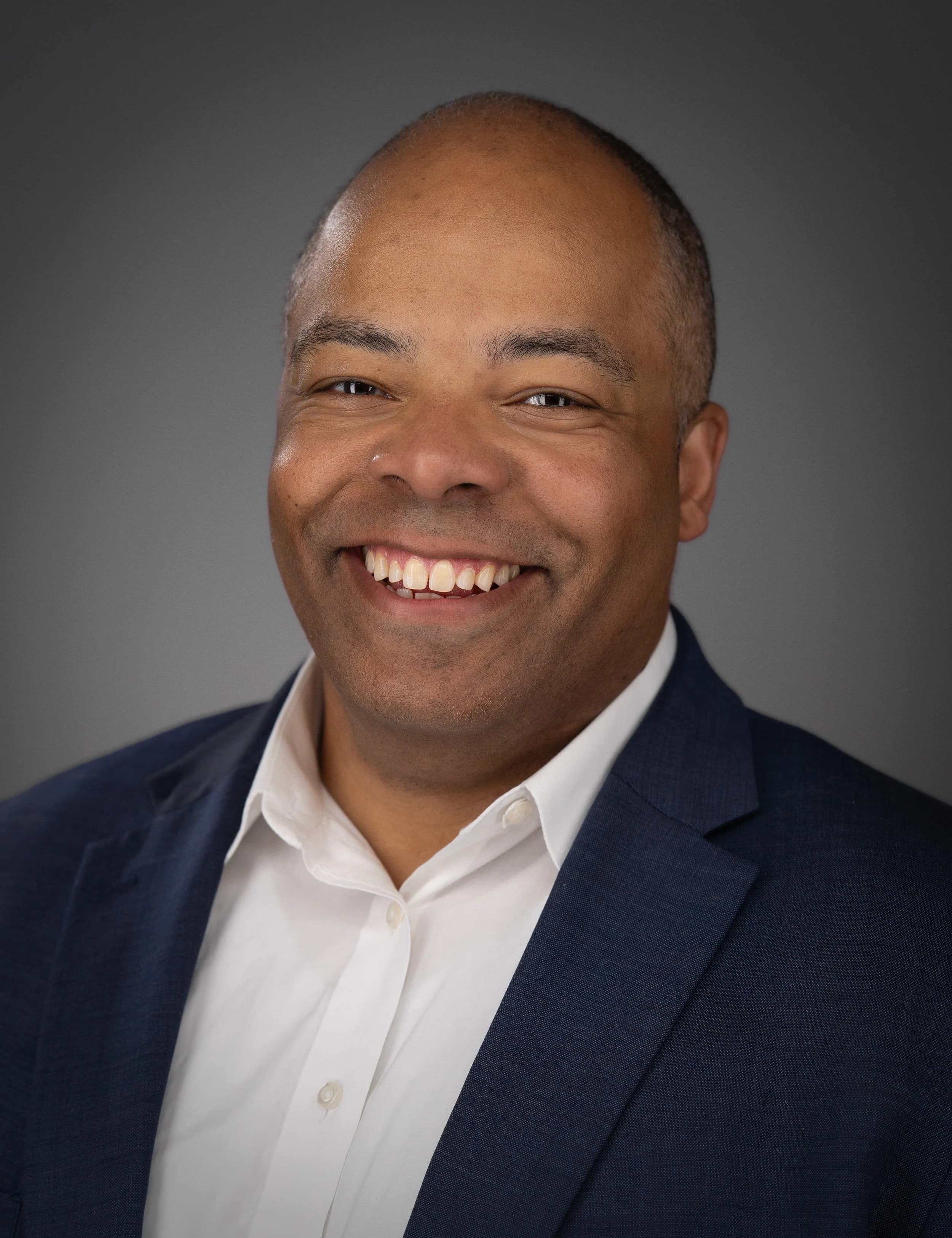 Confident professional studio headshot for LinkedIn and company bios